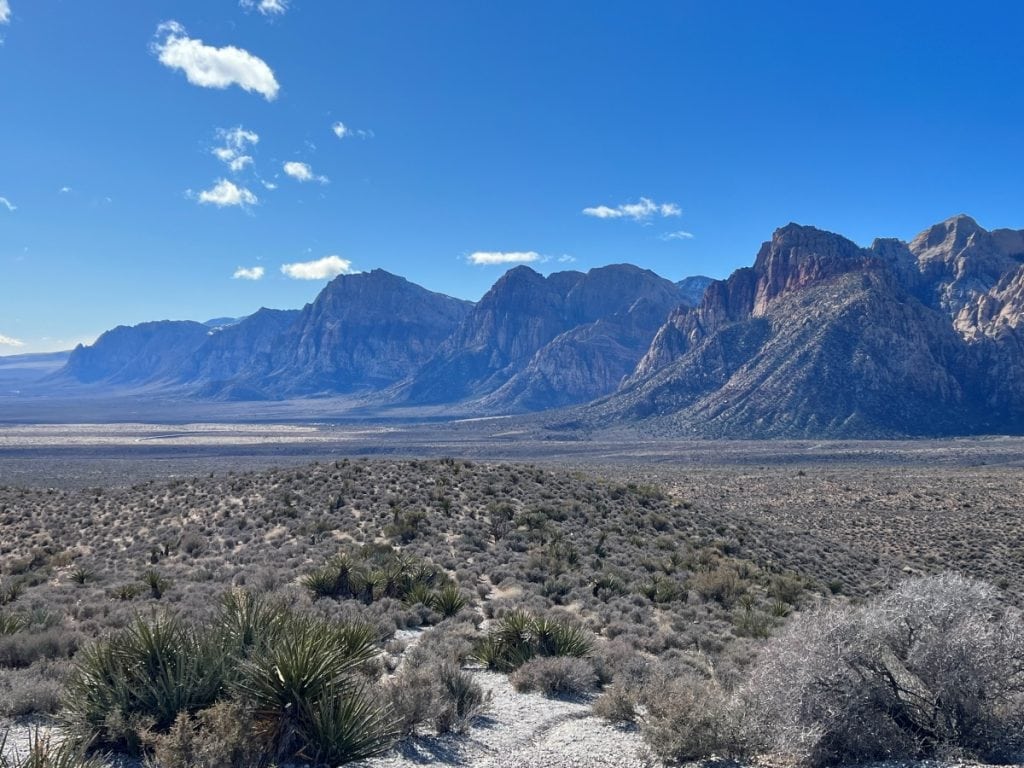 Sweeping vistas at Red Rock Canyon with grey mountains in the background and desert landscape in the front
