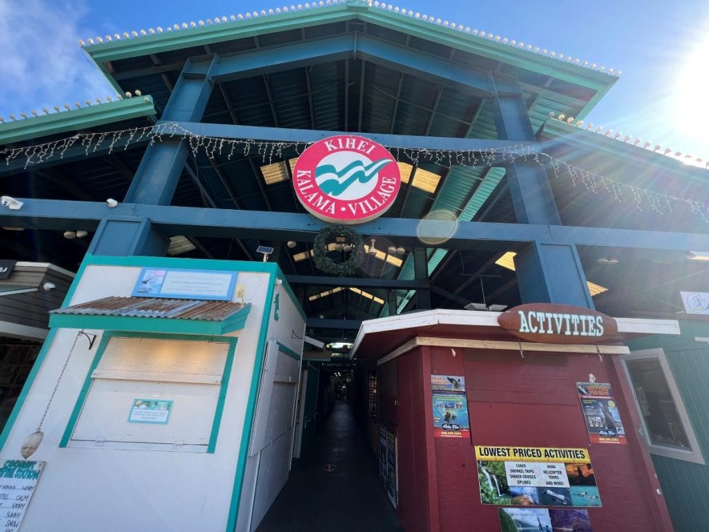 outdoor Shopping mall entrance with the name Kihei Kalama Village at the front in a circular sign
