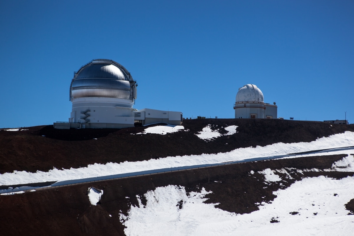 View of Mauna Kea Summit with observatories. There is some snow seen on the mountain peaks in Hawaii.