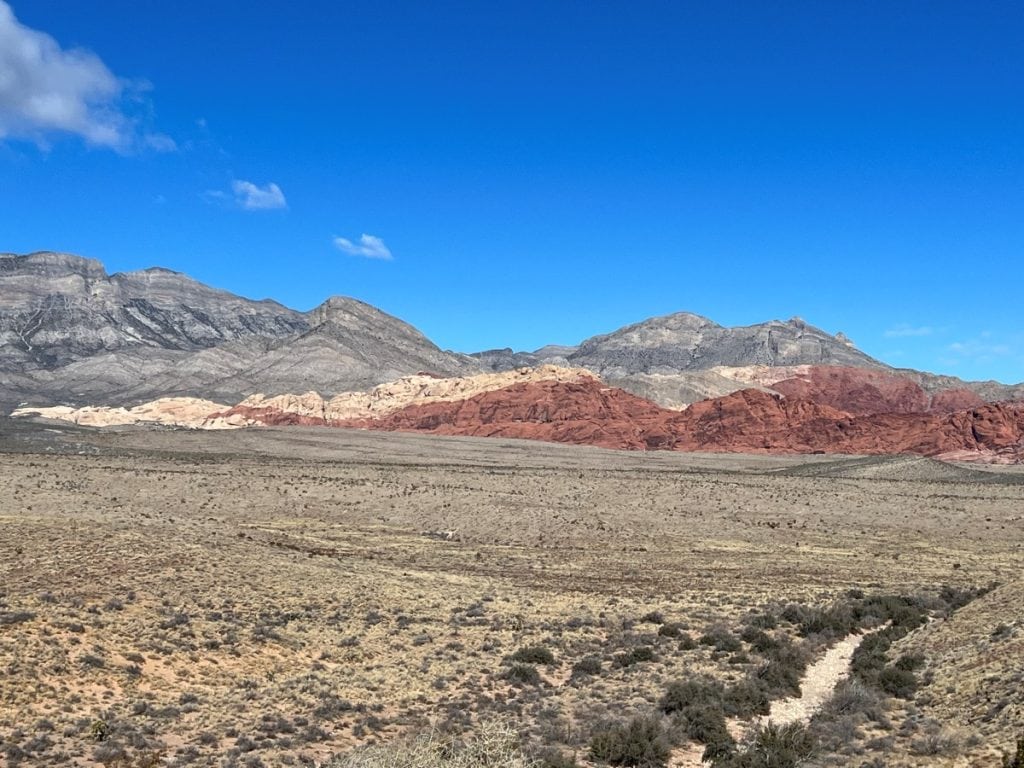 Views of Calico Hills from Red Rock Overlook. Red, cream and grey hills with desert landscape in the front.