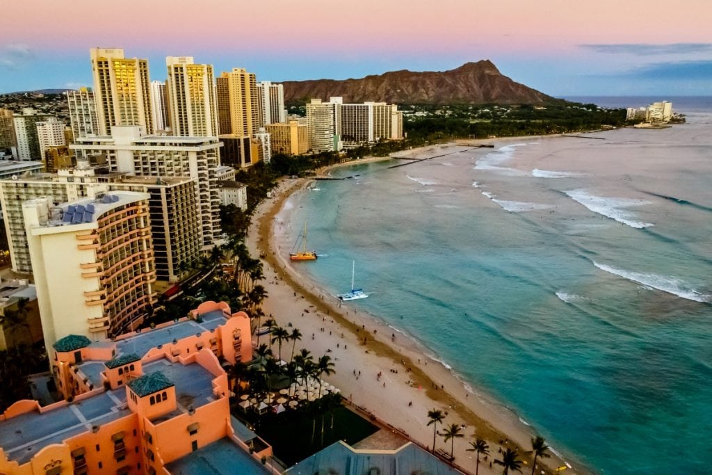 Resort buildings in Oahu, Waikiki Beach, ocean and Diamond Head crater in the backdrop.