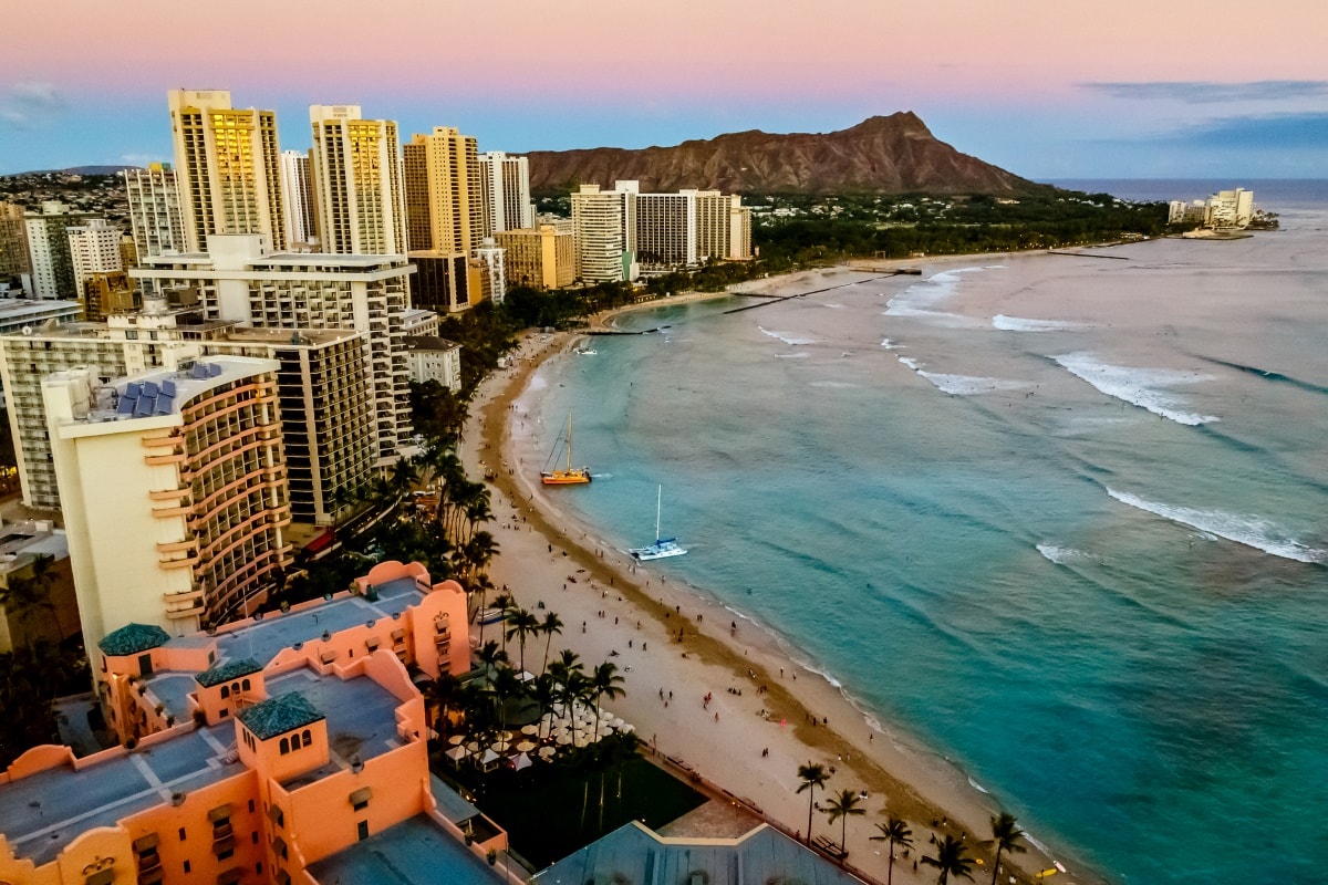 Resort buildings in Oahu, Waikiki Beach, ocean and Diamond Head crater in the backdrop seen from Waikiki helicopter tours. 