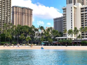 Waikiki Beach with tall resort buildings in the backdrop and ocean in the front