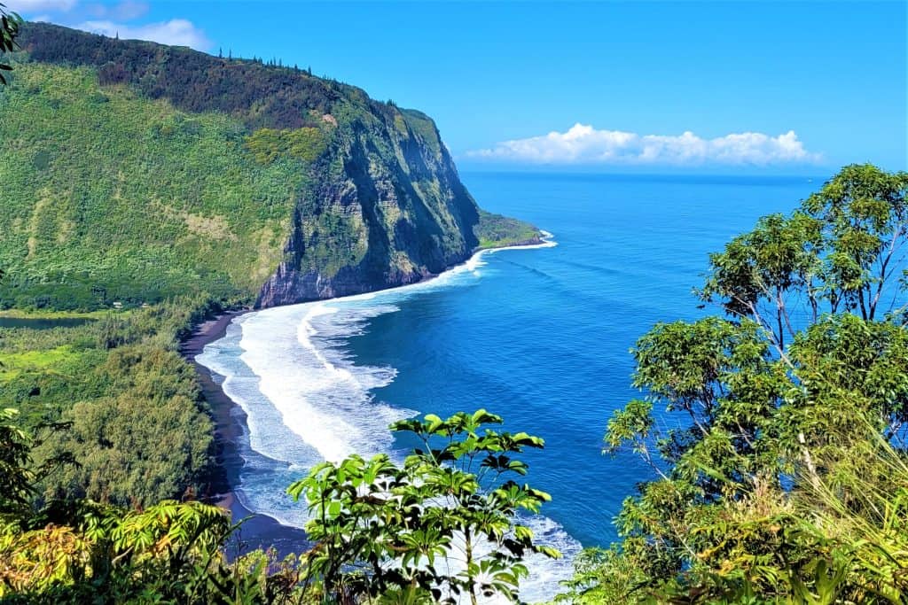 Lush green mountains, valleys and beach with waves in Hawaii during winter