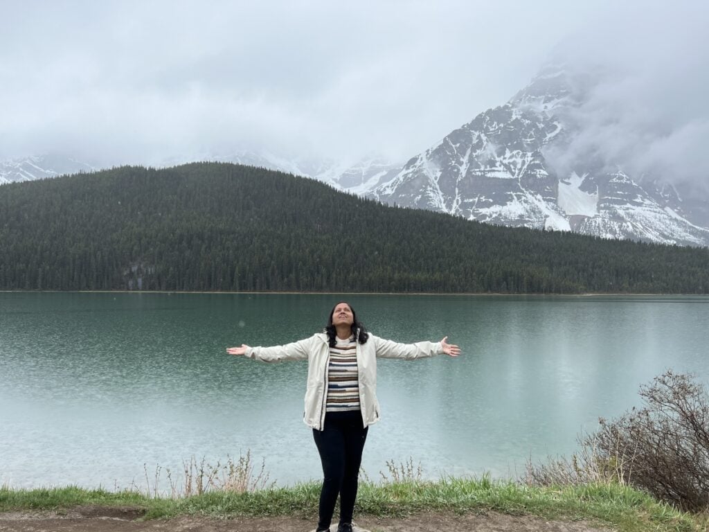 A girl posing in front of a glacial lake