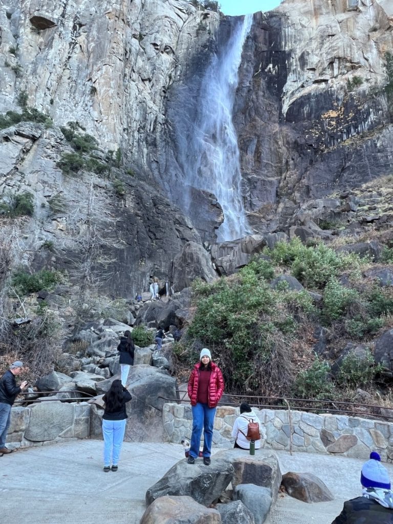 Girl posing in front of the BridalVeil Fall. There are other people on the viewing platform and some that are on the rocks