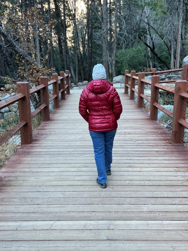 Girl in red jacket walking on a boardwalk