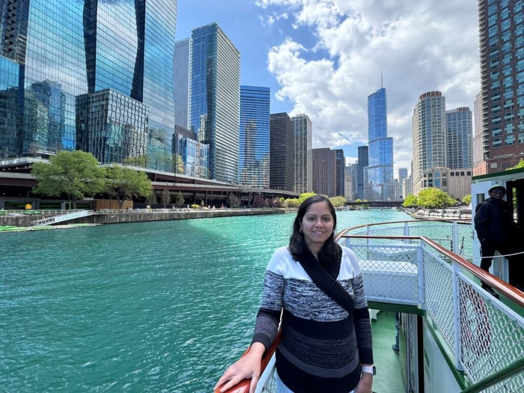 a girl posing on a river cruise boat with the chicago skyline in the backdrop