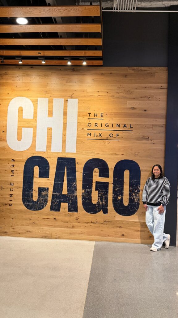 A girl standing in front of a sign that reads Chicago