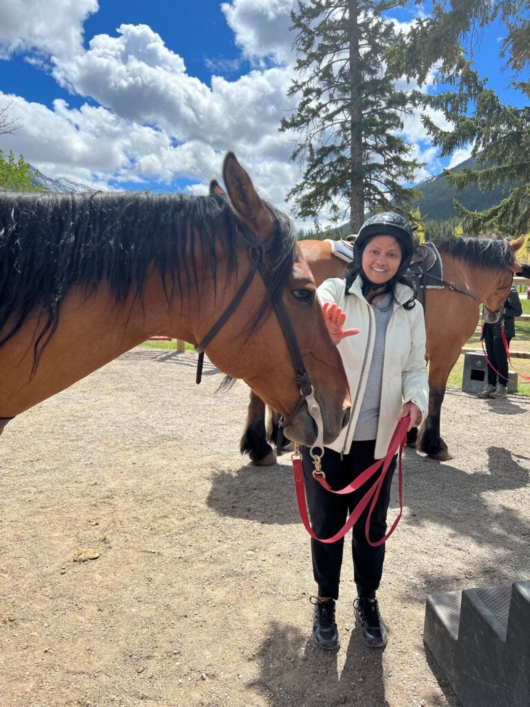 Anu petting a horse in Banff