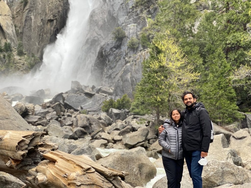 Couple standing in front of a waterfall in Yosemite