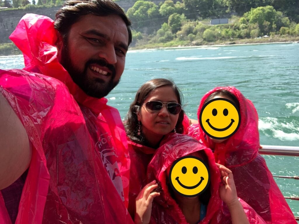 a family on a boat wearing red ponchos