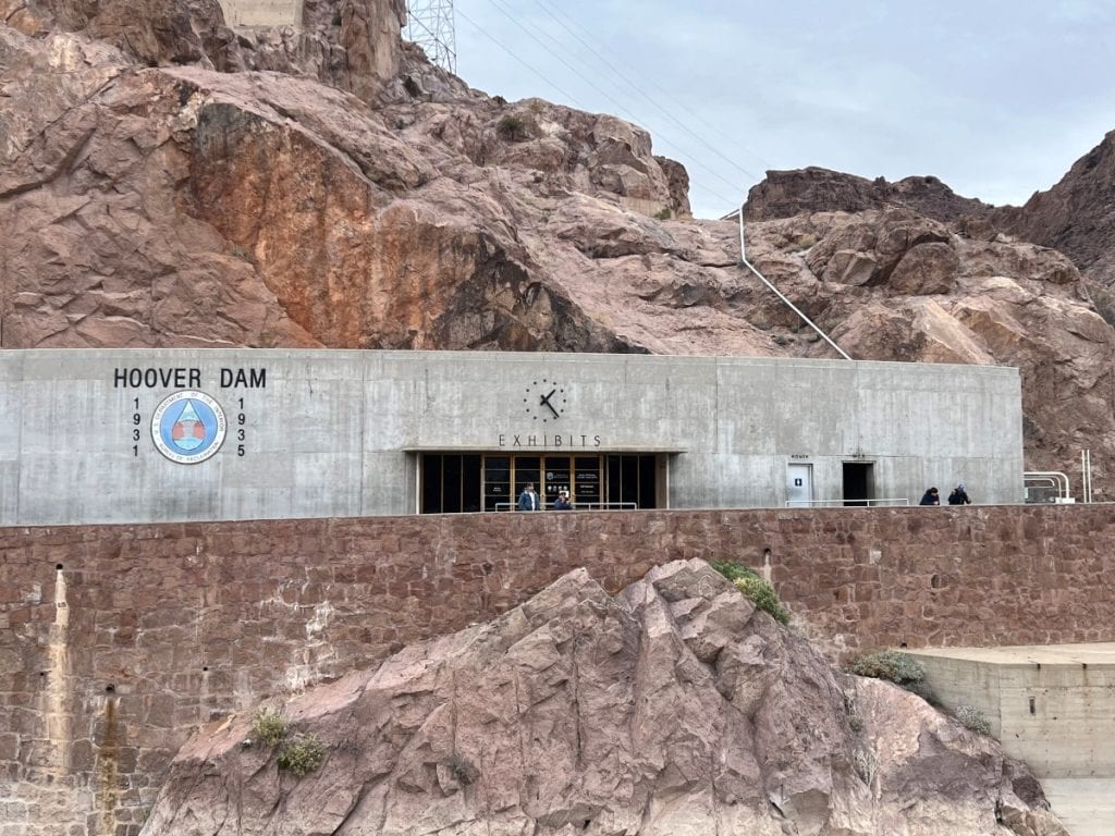 A rectangle concrete building that says exhibits on top at Hoover Dam