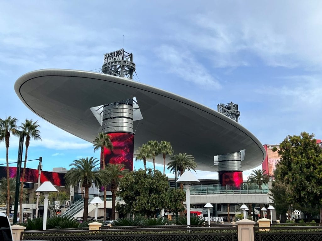 Exterior of Fashion Show Mall in Las Vegas, a large oval disc like structure with red pillars 