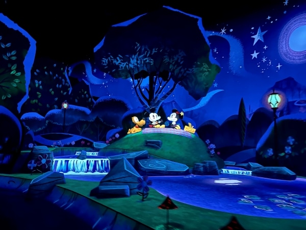 Mickey and Minnie sitting under a tree in a cartoon