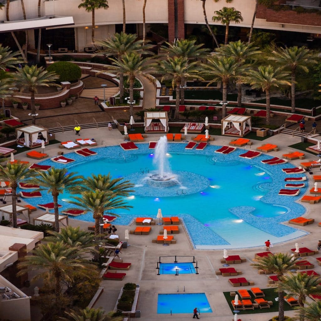 Circular pool area with orange pool lounger chairs around it at Red Rock Resort Las Vegas
